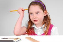 Girl doing math homework with calculator and ruler