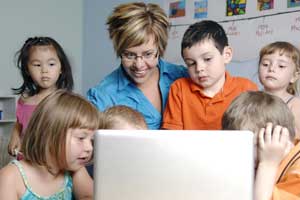 teacher with laptop and students