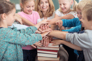 teacher and students joining hands